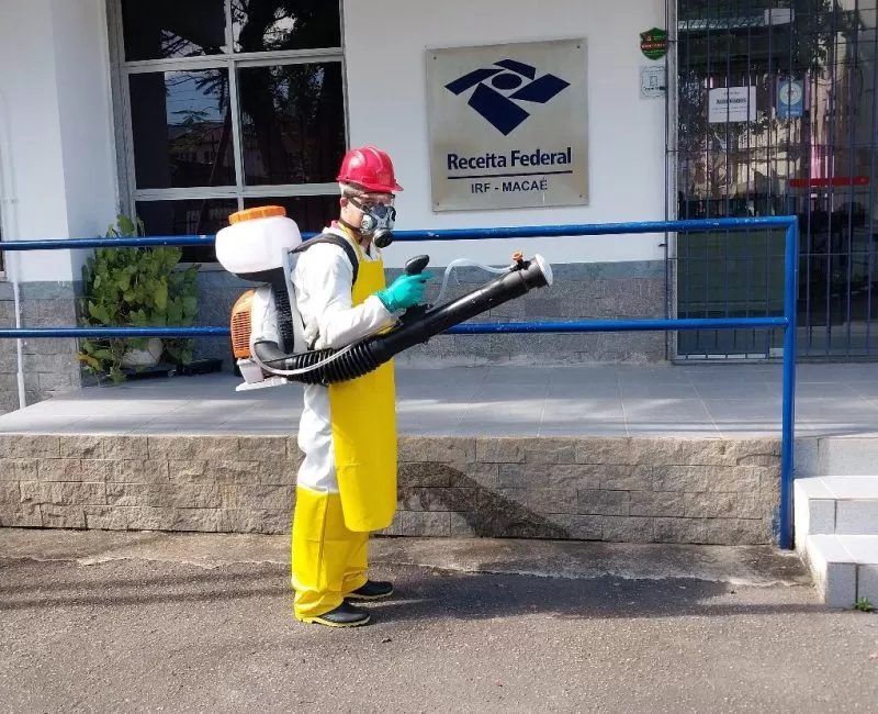 Técnico da Extin Pragas com atomizador costal aplicando serviço na Receita Federal de Macaé, norte fluminense